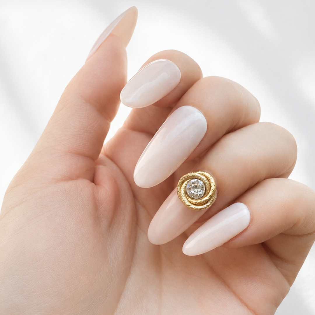 Signature Line Frost brass nail accessory with crystal worn on a pink beige nail.